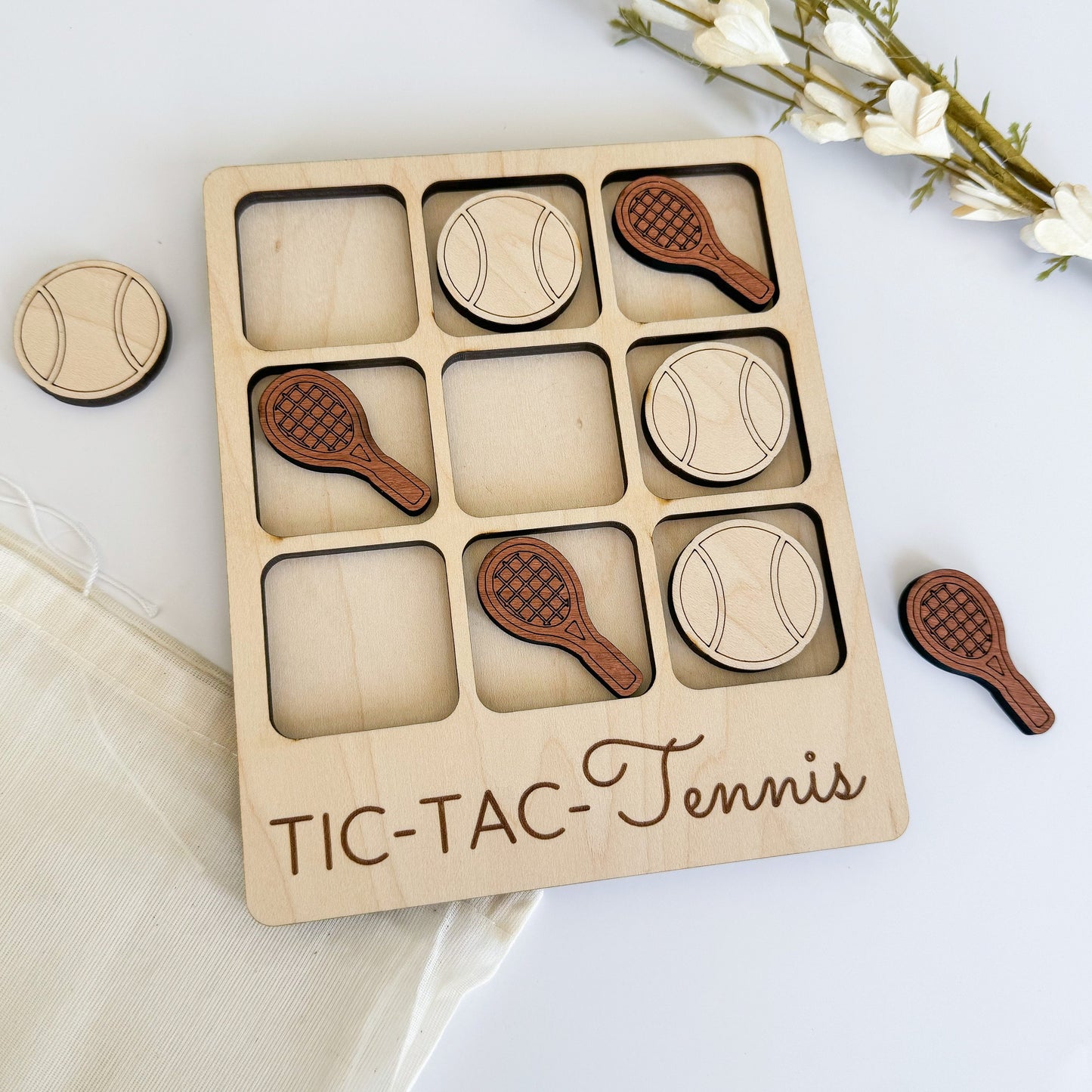 a wooden tic - tac - tennis game with four wooden pieces