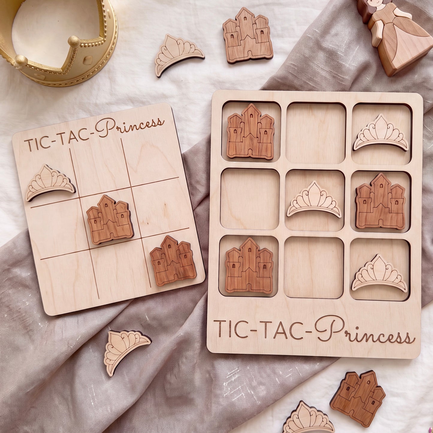 a wooden tic-tac game designed for girls, with a crown and a castle-shaped tile on display.