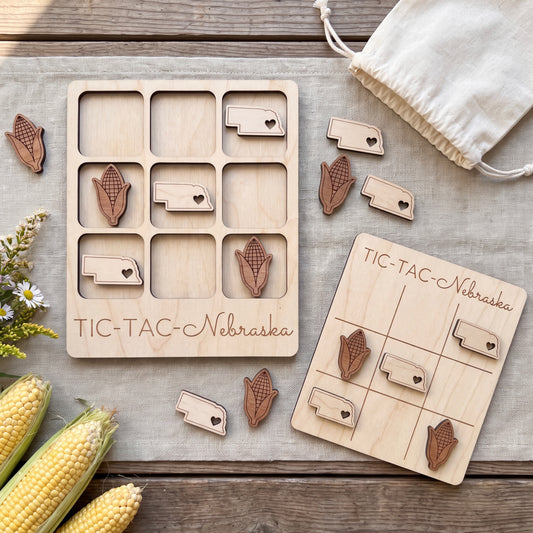 a wooden tic-tac game set with wooden pieces shaped like corn and hearts, placed on a wooden surface alongside some corn cobs and a white cloth.