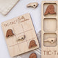 a wooden tic-tac game board with wooden tic-tac pieces, and a wooden tic-tac card with wooden tic-tac pieces.