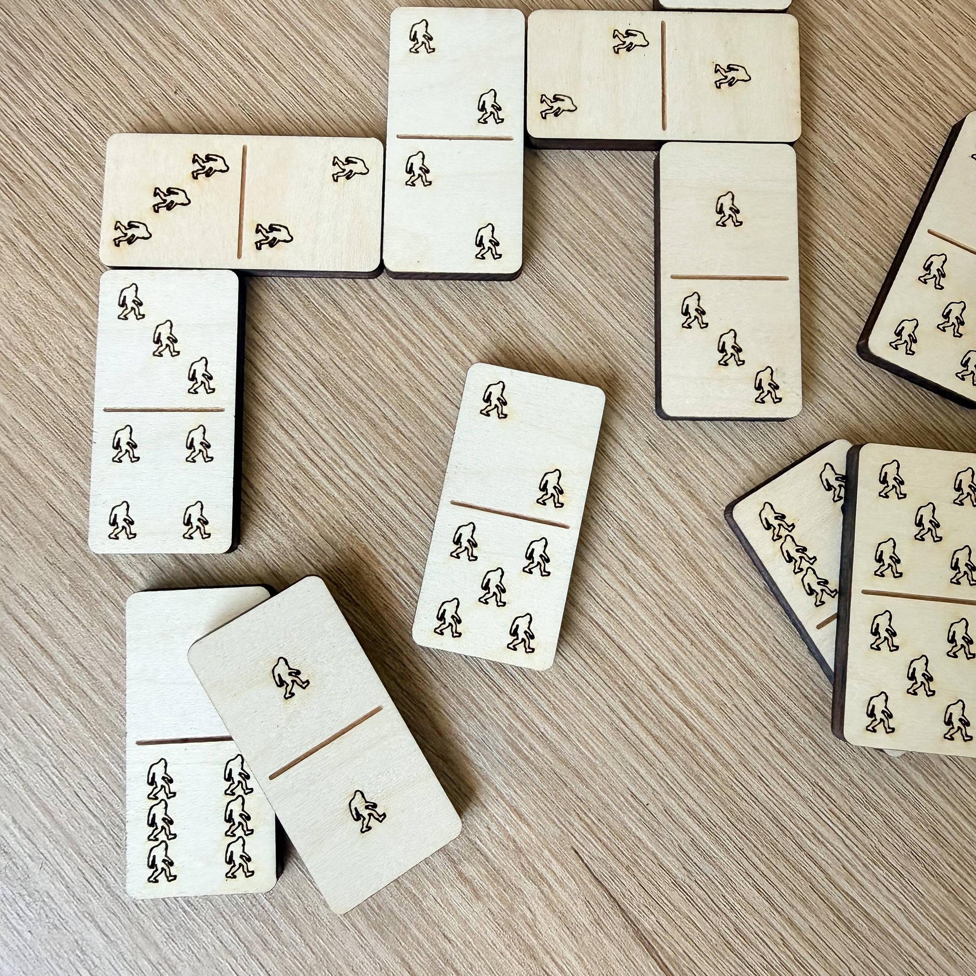 a collection of wooden dominoes arranged on a wooden surface.