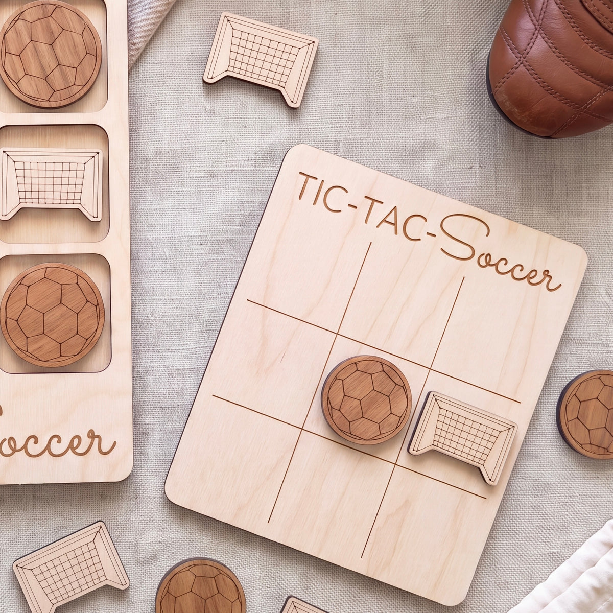 a wooden tic-tac-toe board with soccer-themed stickers, along with a pair of brown shoes and a pair of soccer balls.