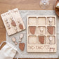 a wooden tic-tac game with wine glass and grape shapes as game pieces, placed on a wooden surface.