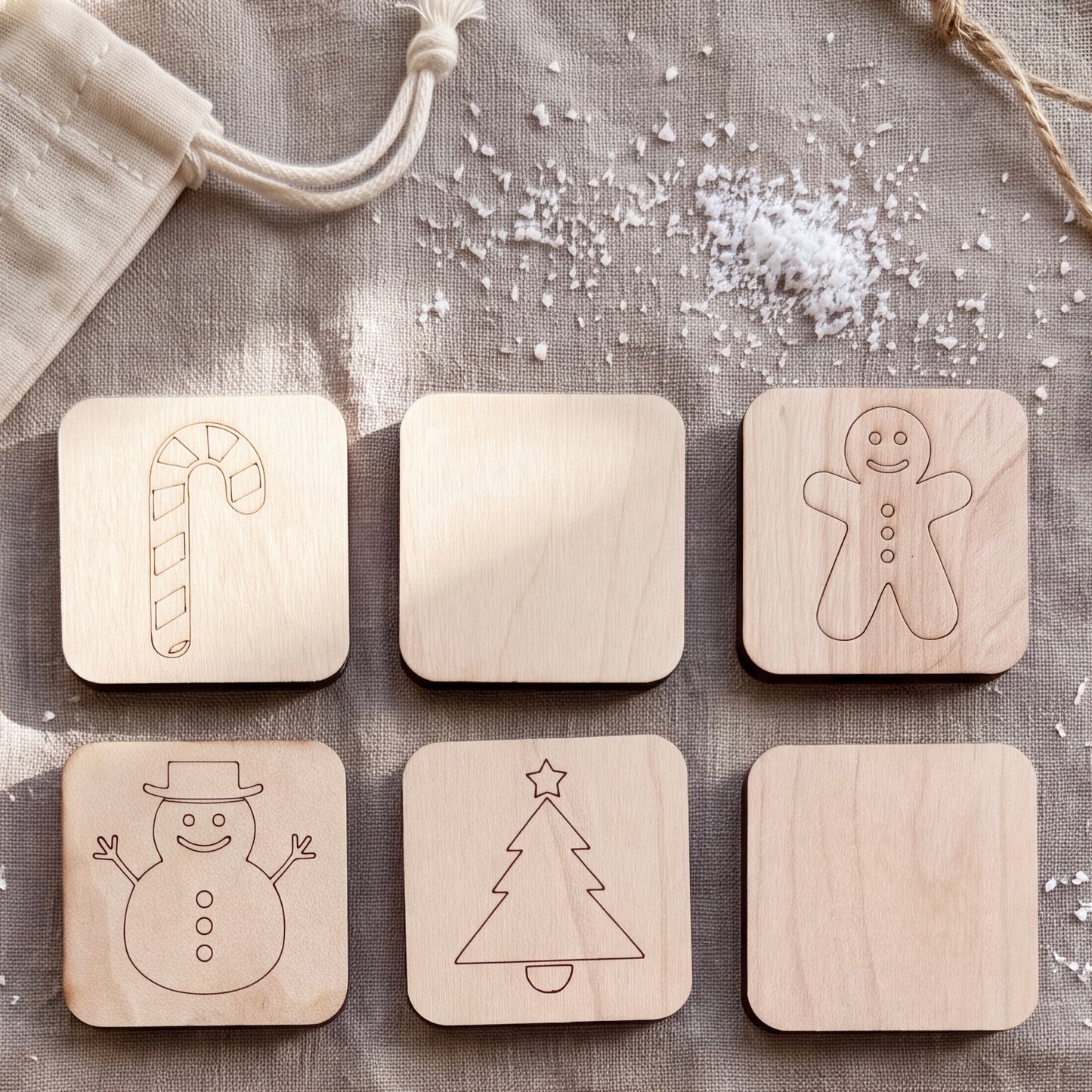 a collection of six wooden coaster-shaped objects, each with a different holiday-themed design. The coasters include a candy cane, a gingerbread man, a snowman, a Christmas tree, a snowman, and a snowman.