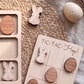 a wooden Easter-themed game board with wooden Easter eggs and a wooden bunny. The game board has the text "TIC-TAC-HOP!" written on it.