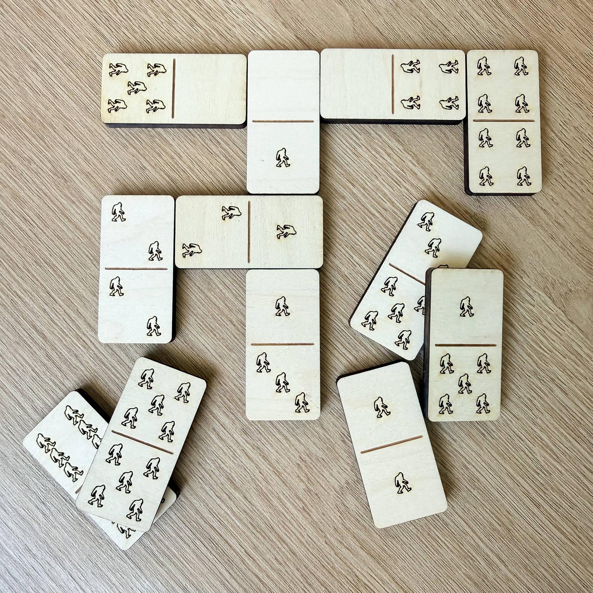 a collection of wooden dominoes arranged on a wooden surface.