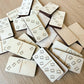 a collection of wooden dominoes with various designs and patterns on them, scattered on a wooden surface.