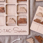 a wooden tic-tac game board with various swimming-themed tiles, including a pool and a swimmer.