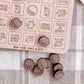 a wooden board game with various labels and a collection of wooden golf-themed game pieces on a table.