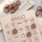 a wooden bingo game board with various phrases and television-themed stickers.