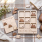 a wooden tic-tac game with Oregon state shapes, placed on a plaid cloth. The game appears to be made of wood and has a rustic, handmade aesthetic.