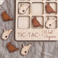 a wooden tic-tac game board with the word "West Virginia" written on it, along with several wooden bird-shaped tiles in the shape of the state of West Virginia.