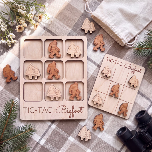 a wooden game board and game pieces shaped like Sasquatch, a fictional creature from the Sasquatch series, arranged on a plaid cloth.