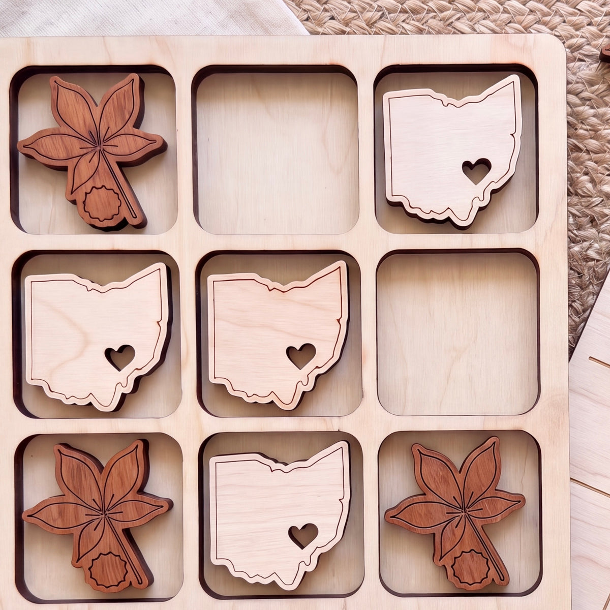 a wooden board with nine cut-out shapes, each representing a different state in the United States. The shapes are arranged in a 3x3 grid, with each state having its own unique design.