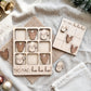 a wooden tic-tac game with Santa Claus and reindeer pieces, along with a white cloth and some Christmas ornaments.