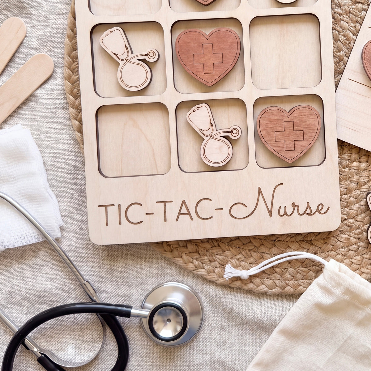 a wooden tic-tac-toe game with a stethoscope and a heart-shaped token, along with other medical-themed items such as a stethoscope and a white cloth.