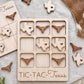 A wooden tic-tac-toe board with Texas state shapes on it, along with some additional wooden shapes.