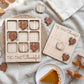 a wooden Thanksgiving-themed game with a pumpkin and turkey design, along with a white plate with a slice of pumpkin pie.