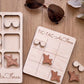 a wooden tic-tac game board labeled "TIC-TAC-AIR FORCE" with wooden airplane and sunglasses pieces attached to it.