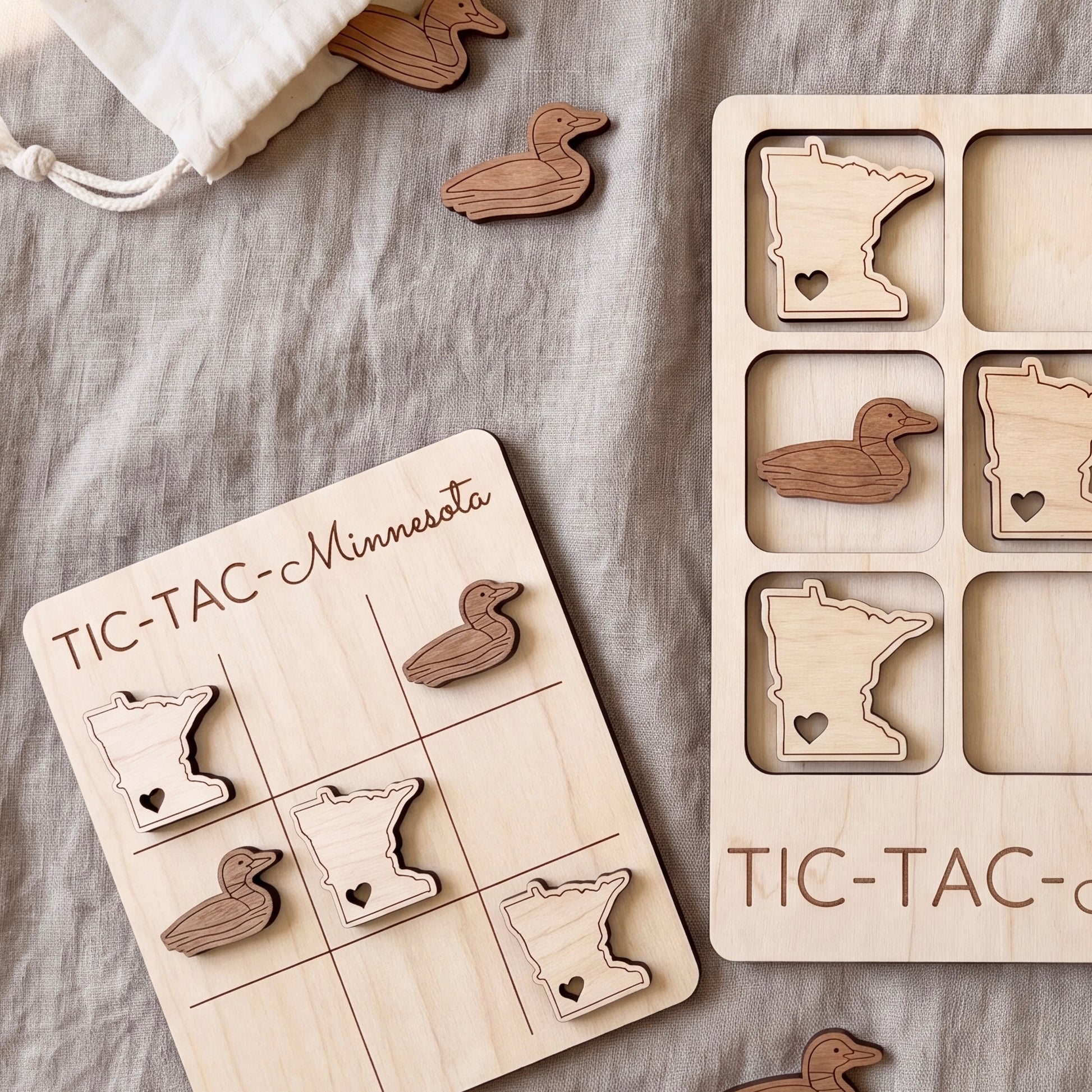 a wooden tic-tac game with Minnesota state shapes as game pieces, and a wooden tic-tac game board with Minnesota state shapes as game pieces.