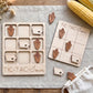 a wooden game board labeled "TIC-TAC-IOWA" and a set of wooden game pieces with cornucopia designs, all placed on a wooden surface.