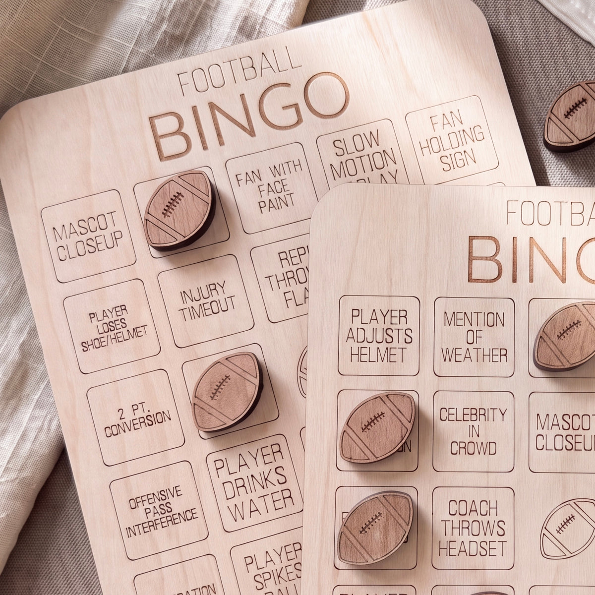 a wooden bingo card with various football-related questions and puns, such as "Mascot Closeup", "Injury Timeout", "Fan with Face Paint", "Repair", "Celebrity in Crowd", and "Offensive Interference".