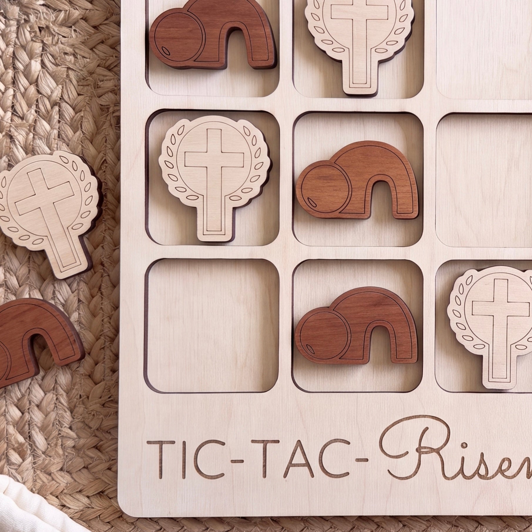 A wooden tic-tac game board with wooden pieces featuring religious symbols, such as crosses and wreaths, arranged in a grid pattern.