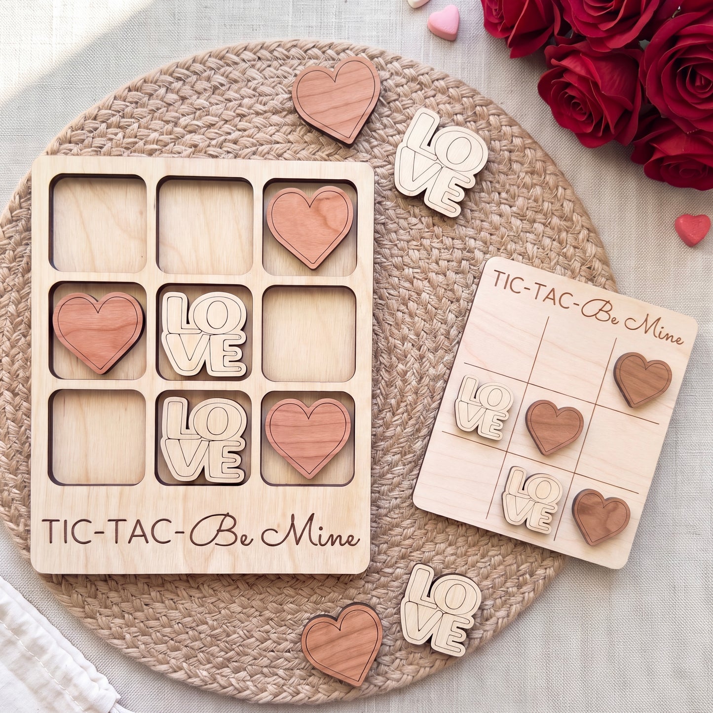 a wooden tic-tac game with the words "Love" written on it, along with wooden hearts. The game is placed on a woven placemat, and there are also some wooden hearts scattered around the game.