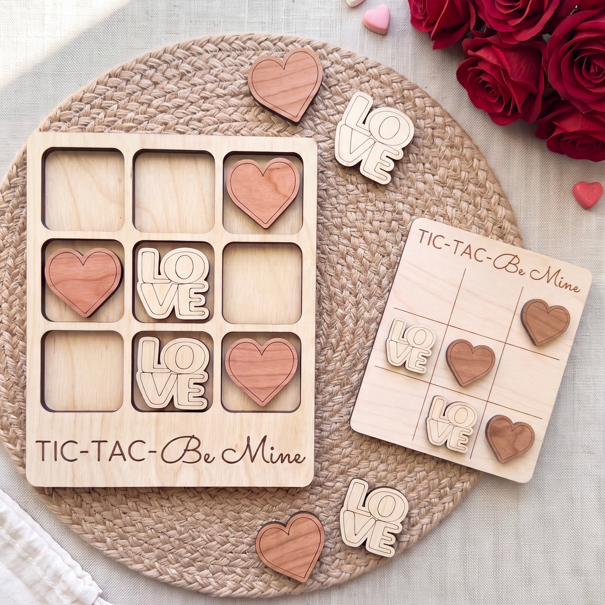 a wooden tic-tac game with the words "Love" written on it, along with wooden hearts. The game is placed on a woven placemat, and there are also some wooden hearts scattered around the game.
