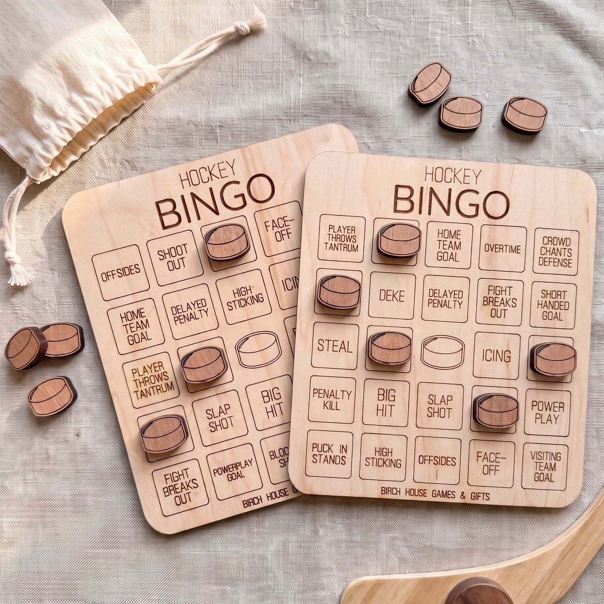 two wooden bingo cards with various hockey-related words and phrases printed on them, along with some wooden bingo pieces scattered around.