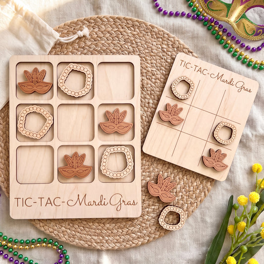 a wooden tic-tac game set with Mardi Gras beads and masks, arranged on a woven placemat.