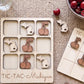 a wooden tic-tac game board with a Michigan theme, including wooden cherries and a bowl of cherries. The board is labeled "TIC-TAC-Michigan".