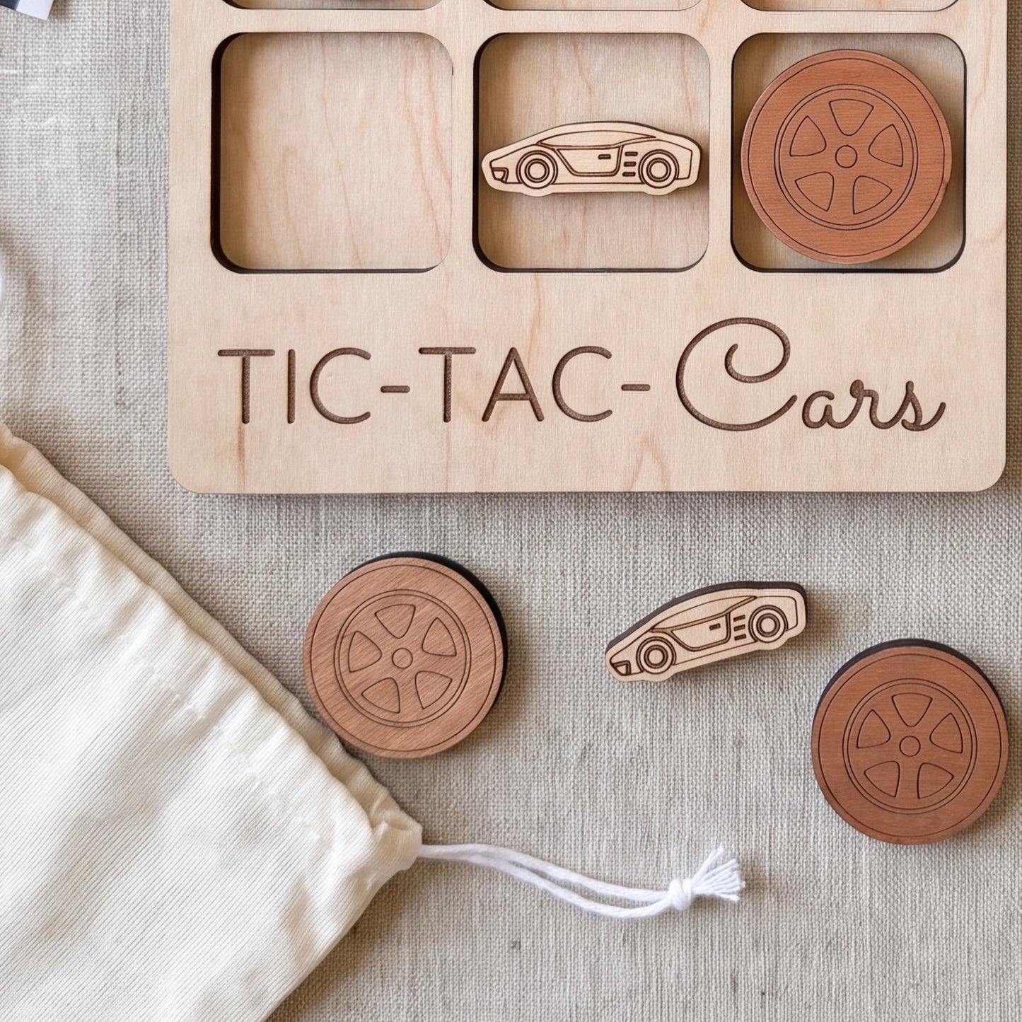 a wooden game board with a car-themed design, along with several wooden car-shaped tiles or blocks.