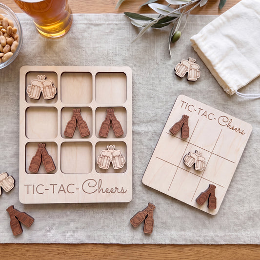 a wooden game board and wooden game pieces, specifically beer mug icons, arranged on a table. There is also a glass of beer visible in the background.