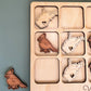 a wooden puzzle with a couple of birds on it