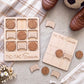 a wooden game board labeled "TIC-TAC-Soccer" and a set of wooden soccer balls, along with a pair of brown shoes, all arranged on a table.