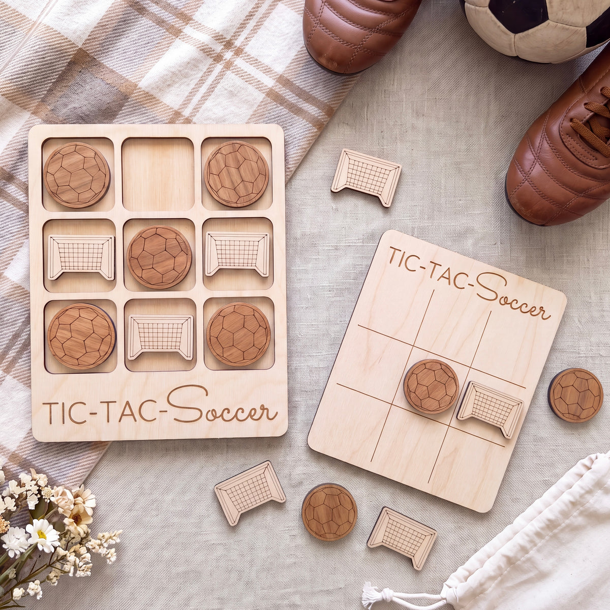a wooden game board labeled "TIC-TAC-Soccer" and a set of wooden soccer balls, along with a pair of brown shoes, all arranged on a table.