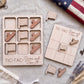 a wooden tic-tac game with a patriotic theme, including an American flag and a tic-tac board with the phrase "TIC-TAC-Come and Take It". The game pieces are also visible, along with a compass and some flowers.