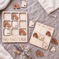 a wooden tic-tac game set with wooden pieces shaped like Utah state icons, placed on a grey surface alongside some flowers.