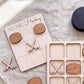 a wooden tic-tac game board with wooden hockey sticks and a black lid, along with a few additional wooden hockey sticks.