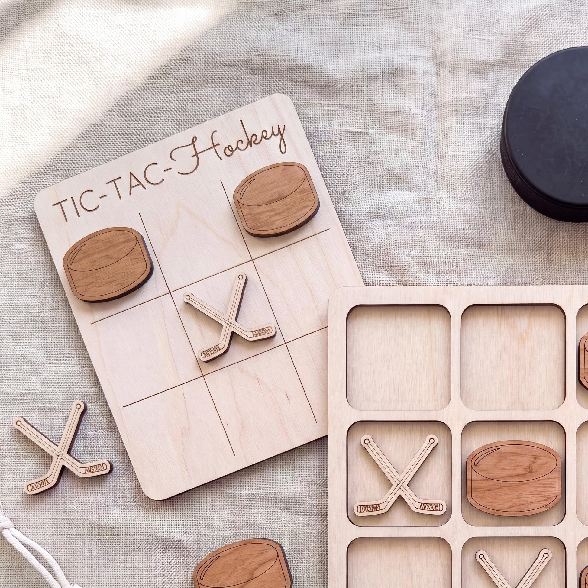 a wooden tic-tac game board with wooden hockey sticks and a black lid, along with a few additional wooden hockey sticks.