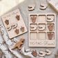 a wooden tic-tac game with dinosaur footprints and dinosaur toys, along with a wooden dinosaur toy.
