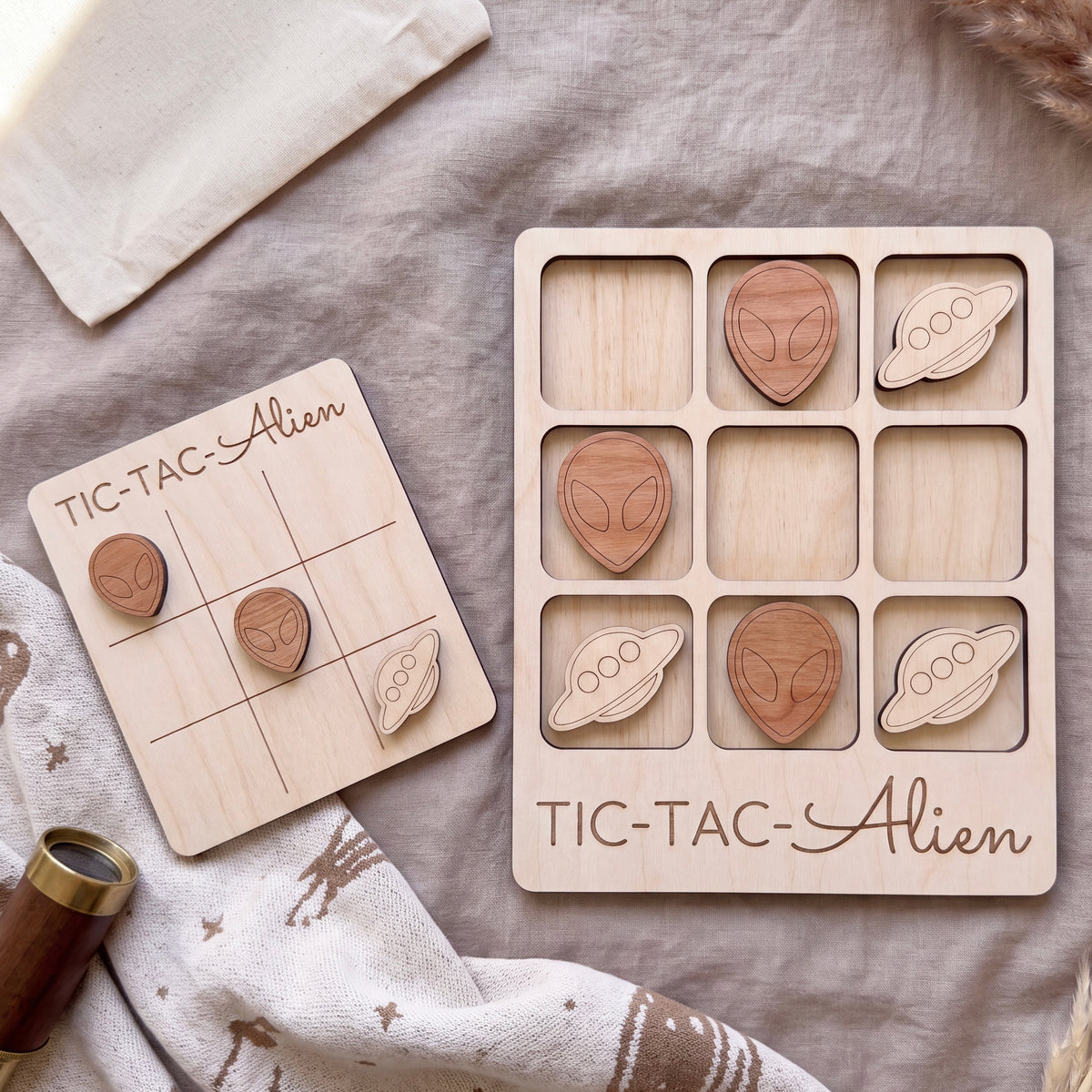 a wooden tic-tac game with alien and spaceship shapes, and a wooden game board labeled "TIC-TAC-Alien".