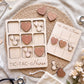 a wooden tic-tac game designed for nurses, with a tic-tac board and wooden hearts shaped like stethoscopes and hearts. The game is surrounded by various medical items, including a stethoscope, a bag, and some flowers.