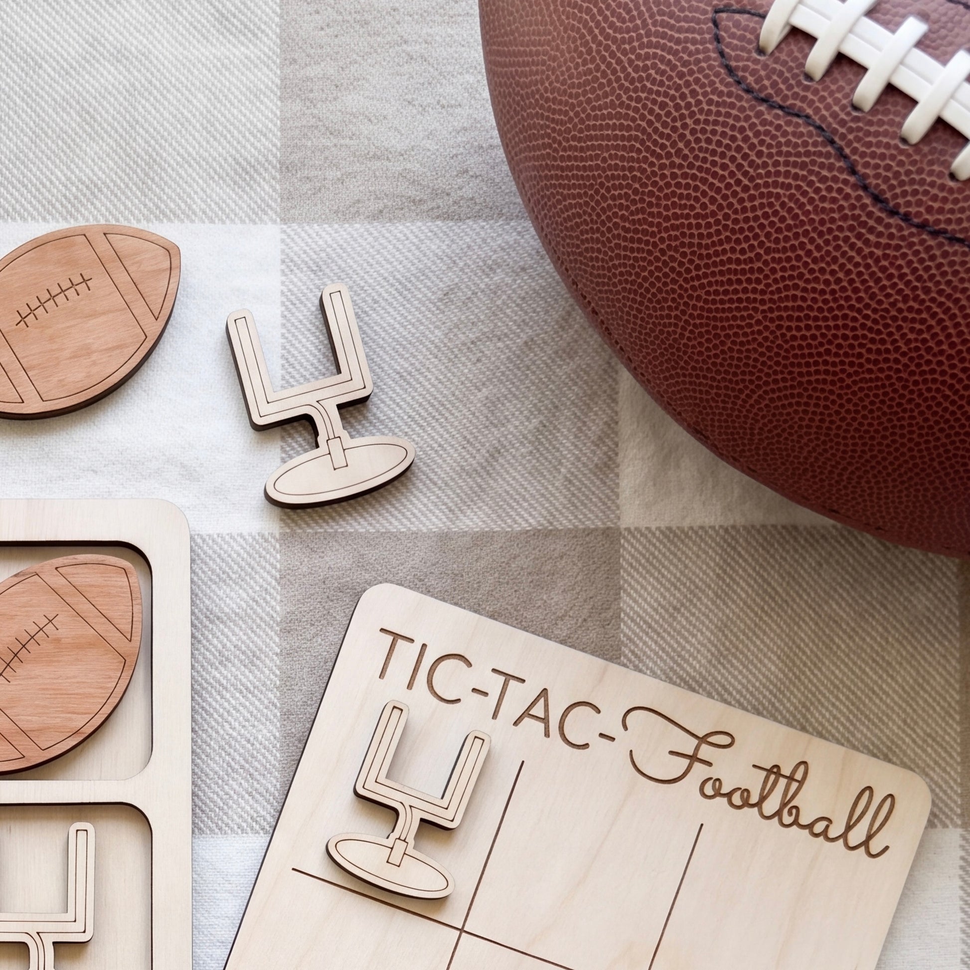 a wooden football game board with the word "TIC-TAC-TAC-TAC-TAC-TAC-TAC-TAC" written on it, along with a wooden football and a wooden tic-tac game piece.