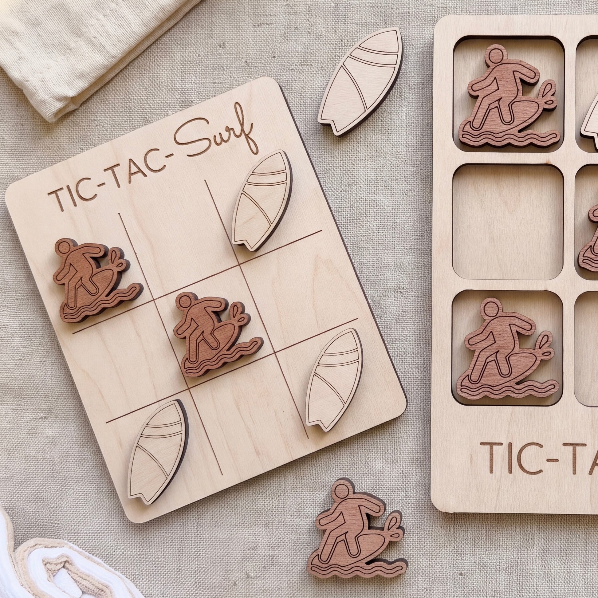 a wooden tic-tac game with a surf theme, including a wooden board with a surfboard and several wooden pieces shaped like surfers.