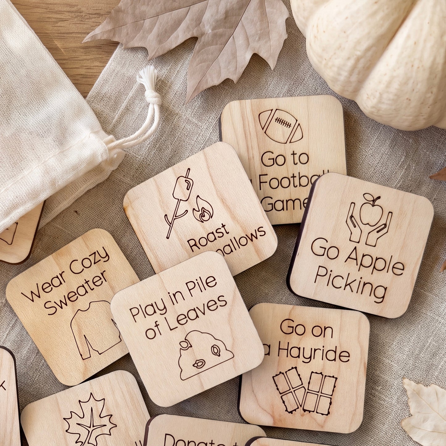 a collection of wooden coasters with various fall-themed illustrations and text, including "Go to Football Game", "Go to Apple Picking", "Go on a Hayride", "Play in Pile of Leaves", and "Go Cozy".