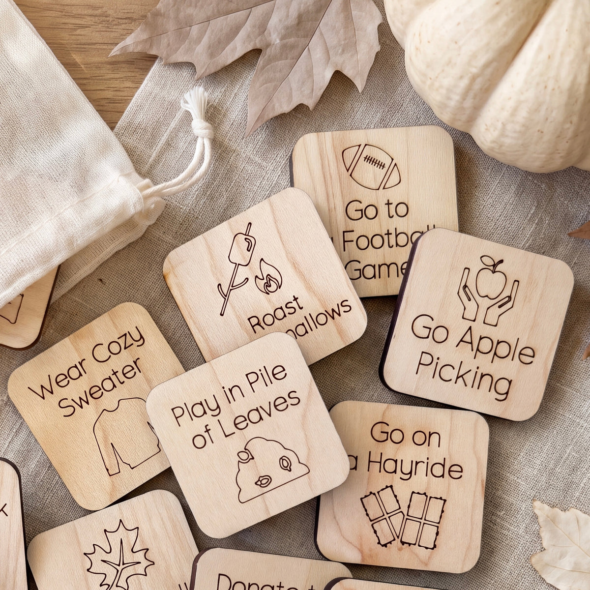 a collection of wooden coasters with various fall-themed illustrations and text, including "Go to Football Game", "Go to Apple Picking", "Go on a Hayride", "Play in Pile of Leaves", and "Go Cozy".