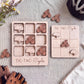a wooden tic-tac game board and a set of wooden bicycle-themed game pieces, all arranged on a table.