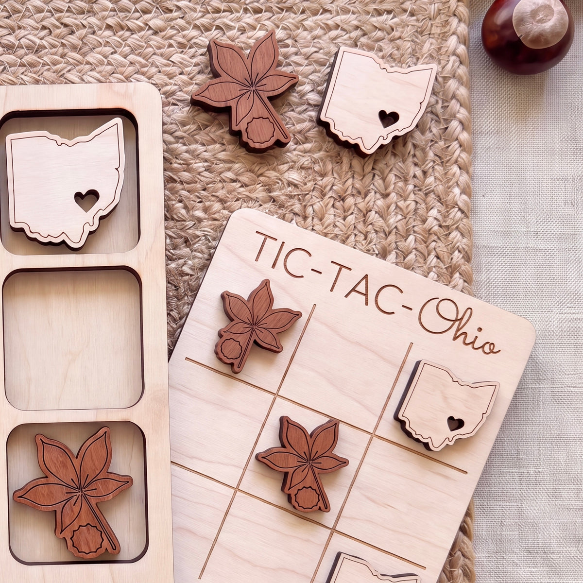 a wooden tic-tac game board with various wooden pieces shaped like flowers and states, including Ohio, placed on it.